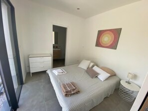 A bedroom with a bed, a dresser, a bedside table, and a wall art piece. - Aix en Provence Villa au Calme Piscine et Pétanque (Cabriès)