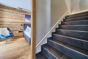 Eine moderne Treppe mit dunklen Marmorstufen und einer Holzverkleidung mit einem Bilderrahmen.