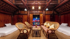 A traditional wooden room with two single beds, a sofa, and two wicker chairs. - Room in Chalet - Trang An Ao Dai Homestay - Wooden House With Field View and Private Bathroom (Hoa Lu)