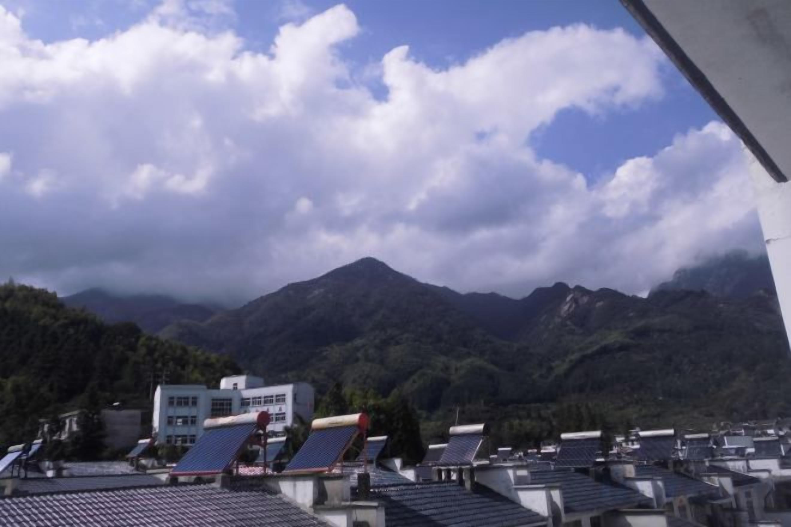 A mountainous landscape with solar panels on rooftops.