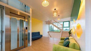 A modern interior with a staircase, a green sofa, and a blue couch. - Room in House - Trang An Ao Dai Homestay - Family Room With Field View and Private Bathroom (Ninh Binh)