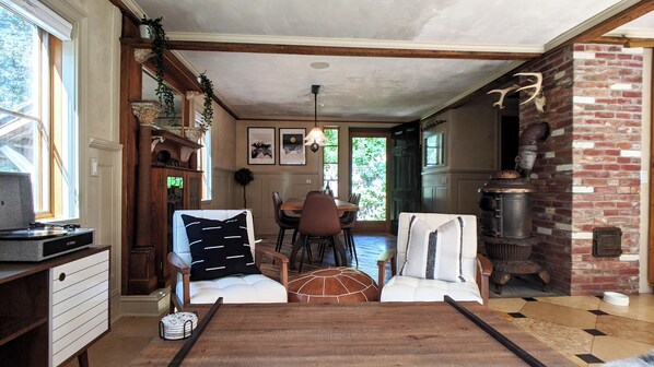 A dining area with a wooden table, chairs, and a chandelier. - Mountain Cabin Getaway With Rustic Charm with Fire Pit! (Cornwall)