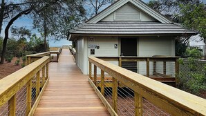 A wooden boardwalk leading to a building with a sign reading "No Toilets." - Sunset Rentals | Beachgate at Starfish 9 Dr. (Hilton Head Island)