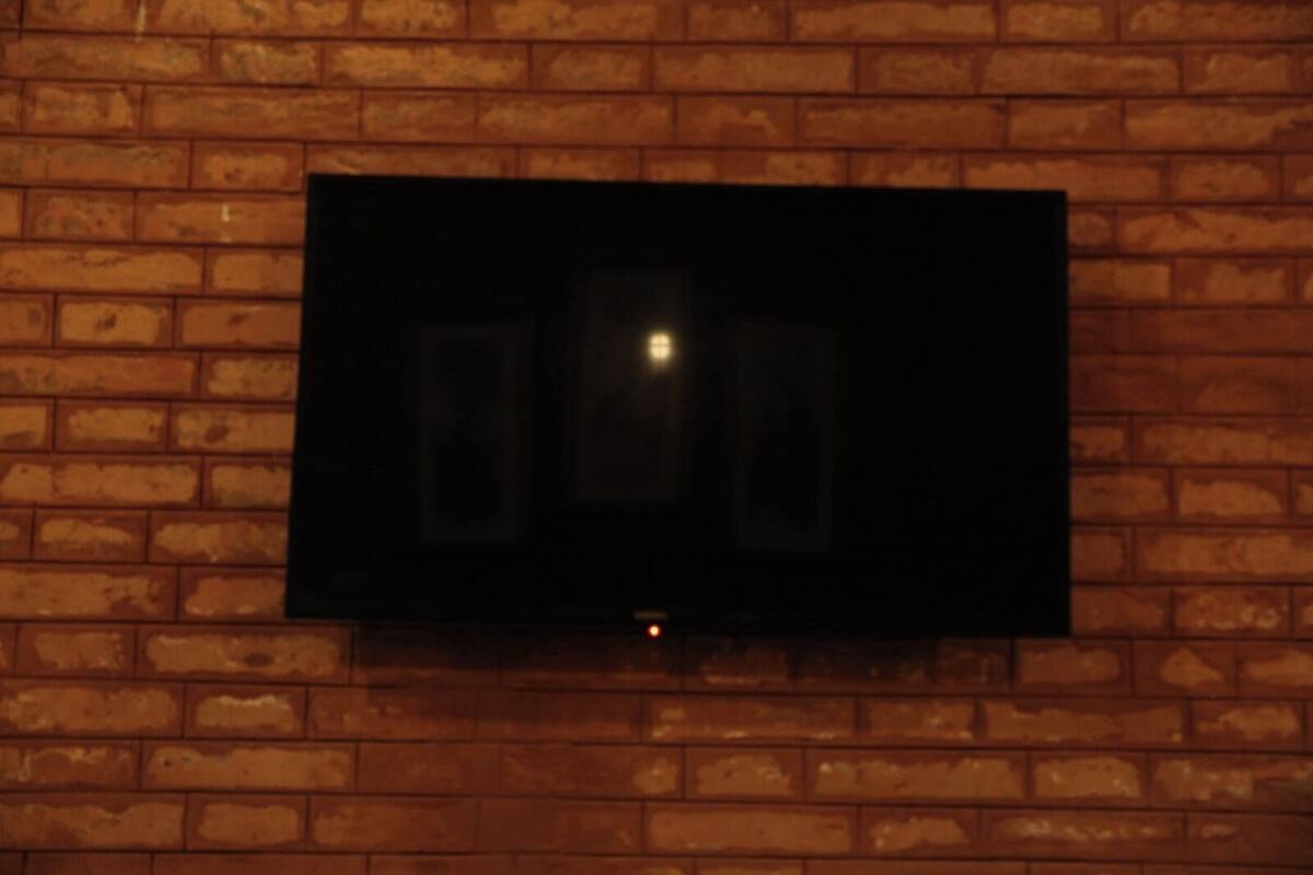 A flat-screen TV mounted on a brick wall.