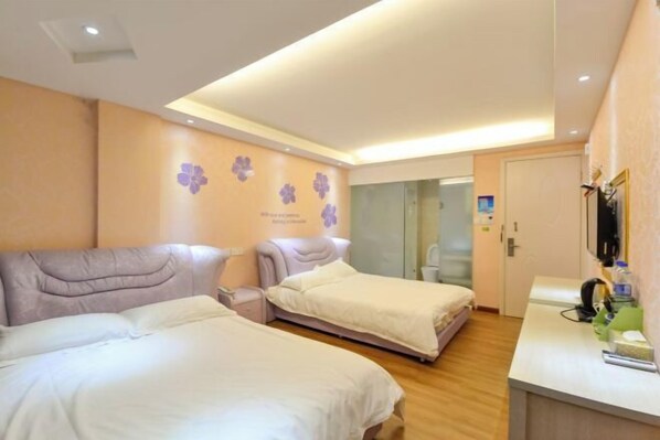 Une chambre d’hôtel avec deux lits, un bureau et une porte vitrée donnant sur une salle de bain.