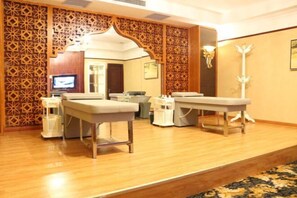 A room with a wooden floor, a patterned wall, and a reception desk.