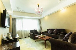 A living room with two sofas, a coffee table, a flat-screen TV, and a chandelier. - Mei Li Hua Hotel (Dezhou)