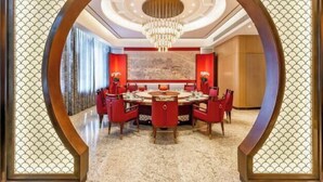 A dining area with a round table, red chairs, and a chandelier. - Mei Li Hua Hotel (Dezhou)