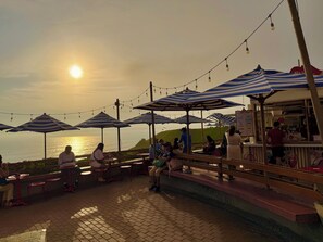 A seaside restaurant with outdoor seating and string lights. - Beautiful ocean view! Spacious and elegant apartment, ideal for families (Miraflores)