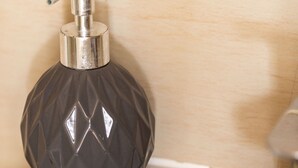 A bathroom with a soap dispenser and a soap bar on a sink. - Cosy Studio in Earls Court Flat 17 (London)