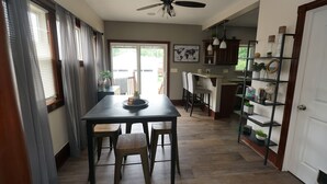A dining area with a table and chairs, a ceiling fan, and a view of the outdoors. - Cozy 3 Bedroom Home (Elyria)