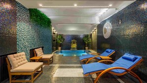 A spa area with a pool, lounge chairs, and a decorative fountain. - Arc de Triomphe by CityBookings (Bucharest)