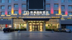 A modern hotel entrance with a large digital display and illuminated signage. - GreenTree GEM International Hotel (Zaozhuang Station Municipal Government) (Zaozhuang)