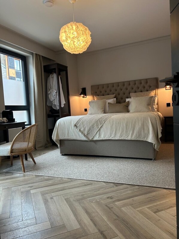 Una habitación de hotel moderna con una cama grande, un escritorio y una silla.
