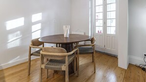 A dining area with a round table and four chairs, a vase, and a chandelier. - Nomad s Family - 3bdr Charming Hideout Porto (Porto)