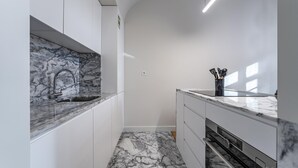 A modern kitchen with marble countertops, a built-in oven, and a sink. - Nomad s Family - 3bdr Charming Hideout Porto (Porto)