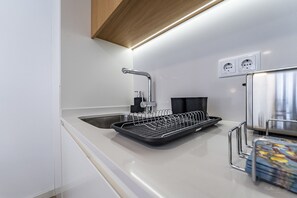 A modern kitchen with a stainless steel sink, a dish rack, and a power outlet on the wall. - Nomad s Lux - 1bdr The Silent Nest in Bonfim (Porto)