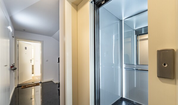 A modern elevator with a metallic finish and a glass door. - Nomad s Lux - 1bdr The Silent Nest in Bonfim (Porto)