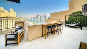 Ein Balkon mit Stadtblick, ein Barbereich und eine Lounge mit Aussicht.