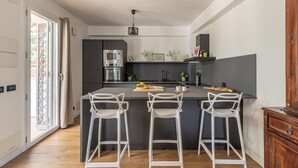A modern kitchen with a central island, bar stools, and a built-in oven. - Villa Giovanna con Piscina by Wonderful Italy (Castellammare del Golfo)