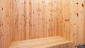 Ein Saunaraum mit Holzwänden und einer Sitzbank.