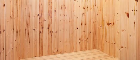A sauna room with wooden walls and a bench.