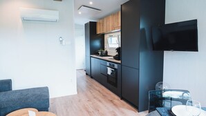 Een moderne keuken met een flatscreen televisie, houten kastjes en een inbouwoven.