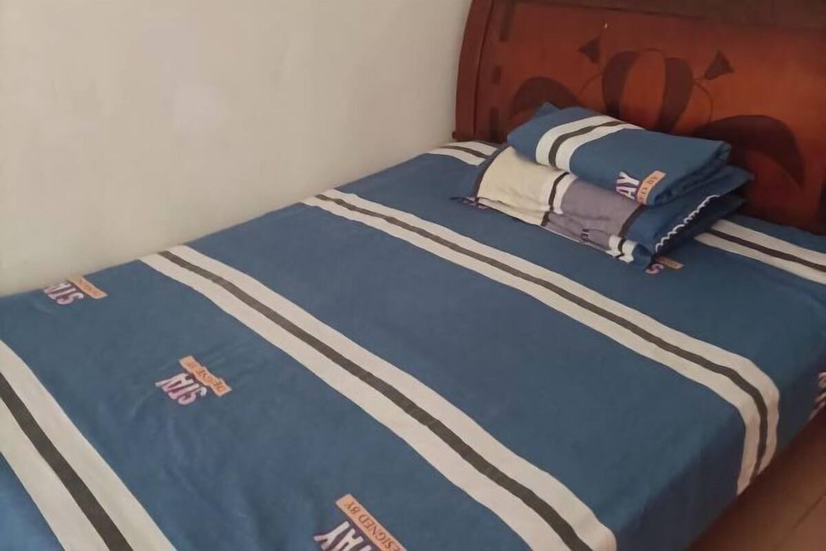 A bed with a blue and white striped bedspread and pillows.