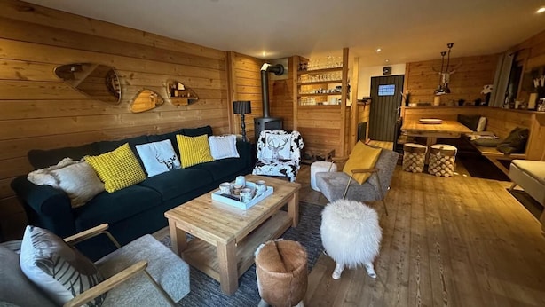 A cozy log cabin interior with a dark green sofa, wooden coffee table, and a fireplace. - Chalet, terrace, fireplace or stove, tv, 150m², Vars (Vars)