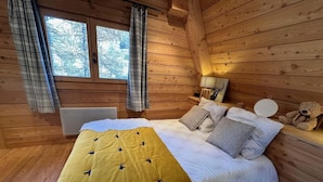 A cozy wooden cabin bedroom with a bed, pillows, a bedside lamp, and a teddy bear. - Chalet, terrace, fireplace or stove, tv, 150m², Vars (Vars)