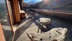 A wooden deck with rustic furniture and a view of mountains. - 5th floor, balcony, tv, ski locker, 65m², Vars (Vars)