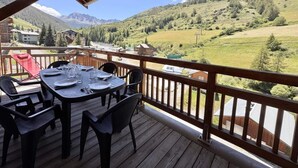 A wooden deck with a table set for dining, overlooking a mountainous landscape. - 3rd floor, balcony, tv, ski locker, 80m², Vars (Vars)