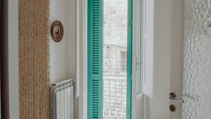 A hallway with a white radiator, a door with teal shutters, and a textured wall. - Nina Delle Palme in Monopoli (Monopoli)