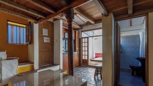 Une pièce spacieuse avec un plafond en bois, une grande fenêtre et une vue sur un balcon.