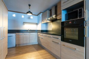A modern kitchen with wooden cabinets, a built-in oven, and a dishwasher. - 100m from ski slopes, 3rd floor, balcony, fireplace or stove, tv, ski locker, 160m², Val Thorens (Val Thorens)