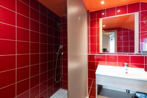 Bathroom features a sink, mirror, and handheld showerhead.