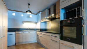 A modern kitchen with wooden cabinets, a built-in oven, and a dishwasher.