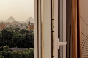 A view of the pyramids from a window, with buildings and trees in the foreground. -  La Veranda Pyramids Boutique Hotel (Giza)