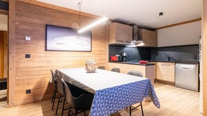 Una cocina moderna con armarios de madera, encimera negra y lavavajillas integrado.