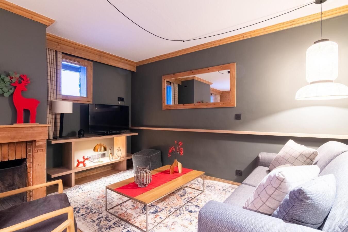 A modern living room with a fireplace, television, sofa, and decorative items.