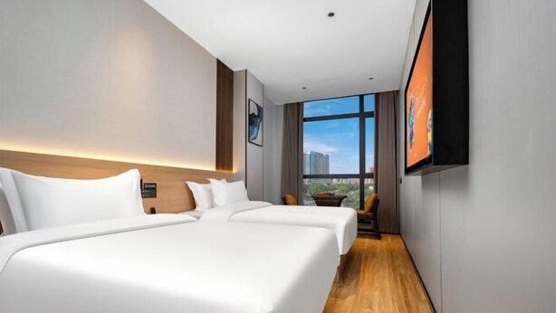 A hotel room with two beds, a TV on the wall, and a view of the city. - City 118 Chain Hotel Zhengzhou Economic Development Zone (Zhengzhou)