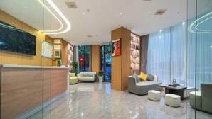A modern hotel lobby with a reception desk, seating area, and large windows. - City 118 Chain Hotel Zhengzhou Economic Development Zone (Zhengzhou)