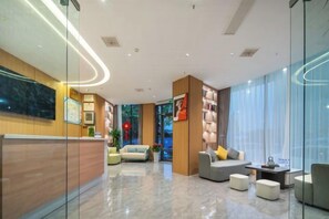 A modern hotel lobby with a reception desk, seating area, and a large window offering a view. - City 118 Chain Hotel Zhengzhou Economic Development Zone (Zhengzhou)
