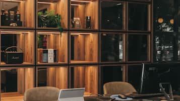 Un interior moderno con una estantería de madera, una mesa de vidrio y dos sillas.
