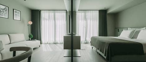Ein modernes Hotelzimmer mit Bett, Sofa, Schreibtisch und Stuhl.