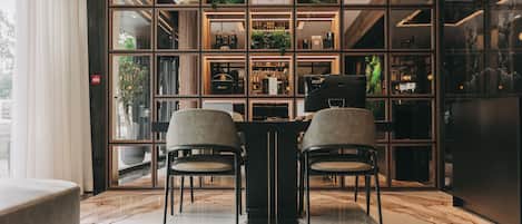 A modern interior with a bar area, two chairs, and a marble floor.