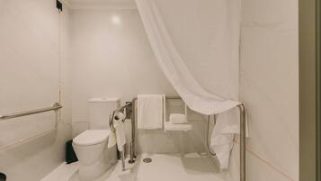 A modern bathroom with a toilet, bidet, and shower area.