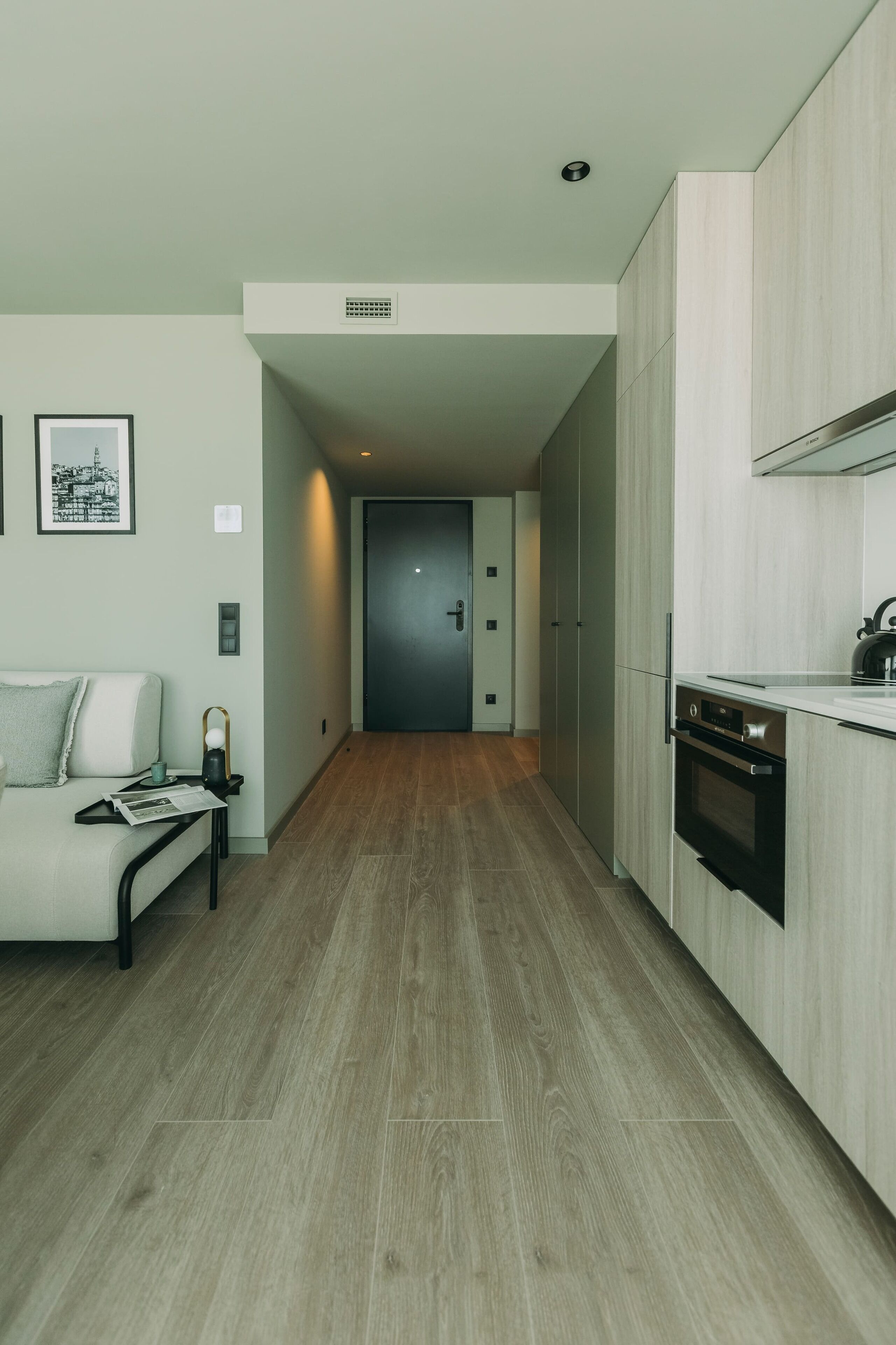A modern kitchen with wooden cabinets, a built-in oven, and a countertop.