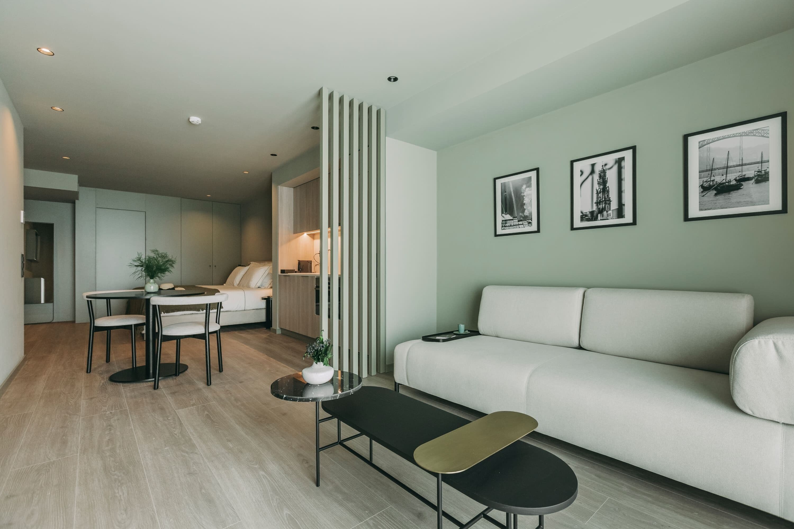 Una sala de estar moderna con un sofá, una mesa de comedor con sillas y una cocina al fondo.