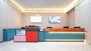 En reception med moderne design, med skranke, siddeområde og et stort skærmbillede på væggen.